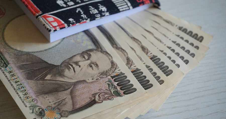 ธนบัตรเยนวางอยู่บนหนังสือเรียนภาษาญี่ปุ่น
